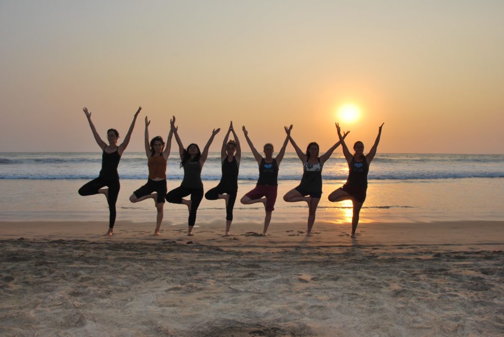 girls at kerala beach doing yoga