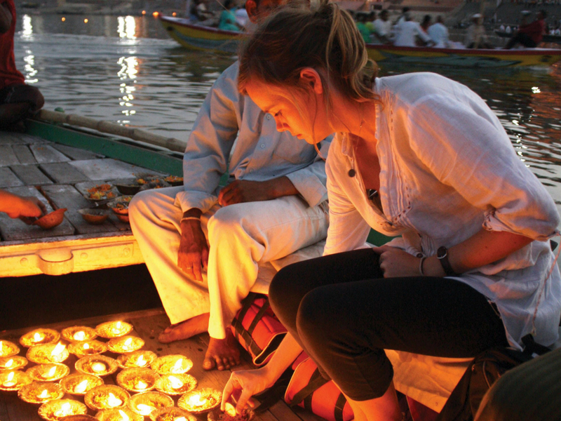 foreigner lighting divas at varanasi ghat during diwali