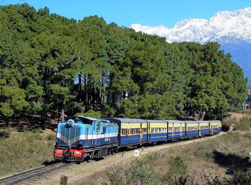 kangra valley toy train in india with snow captured mountains